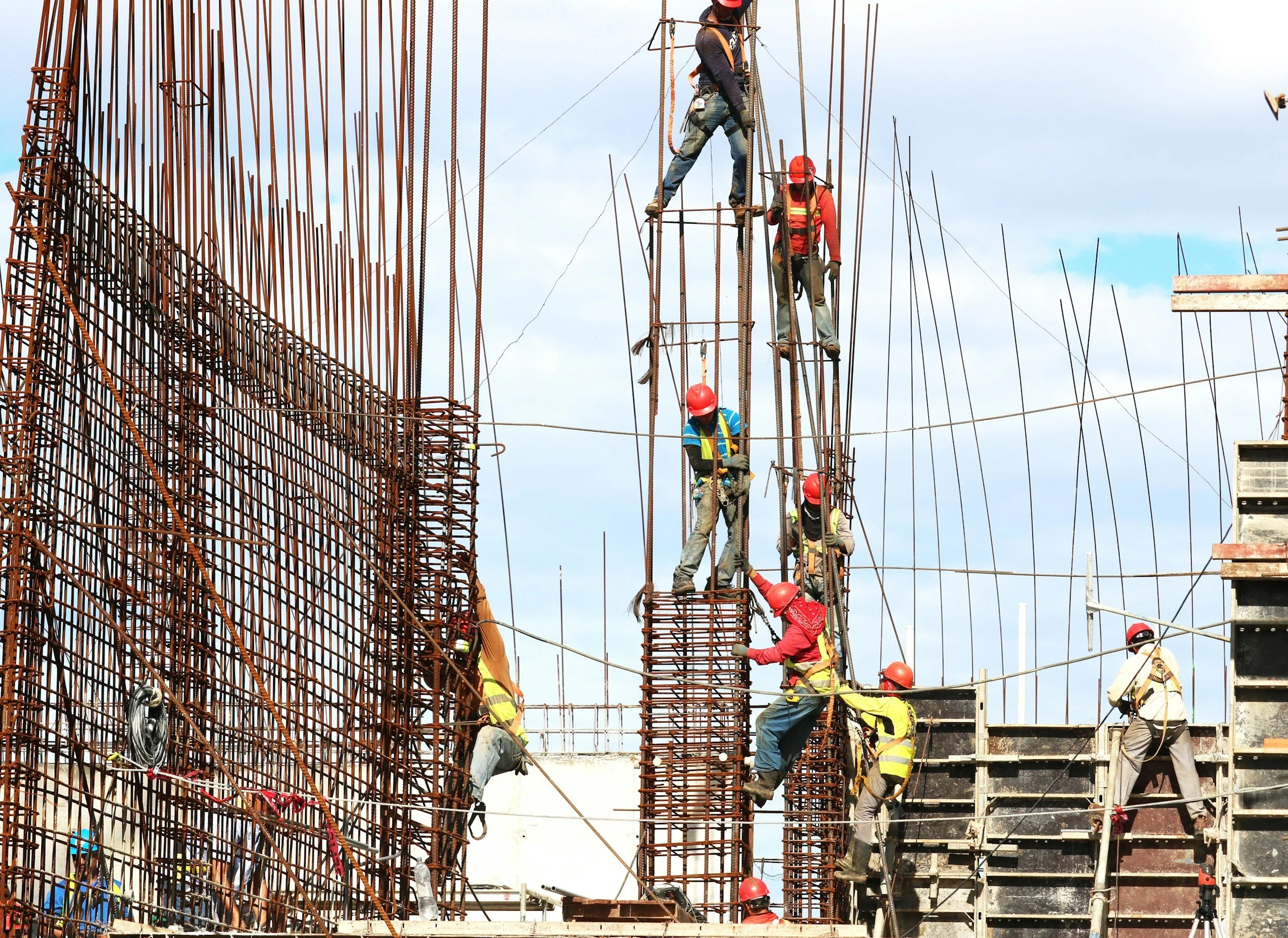 a group of construction workers working on rebar
